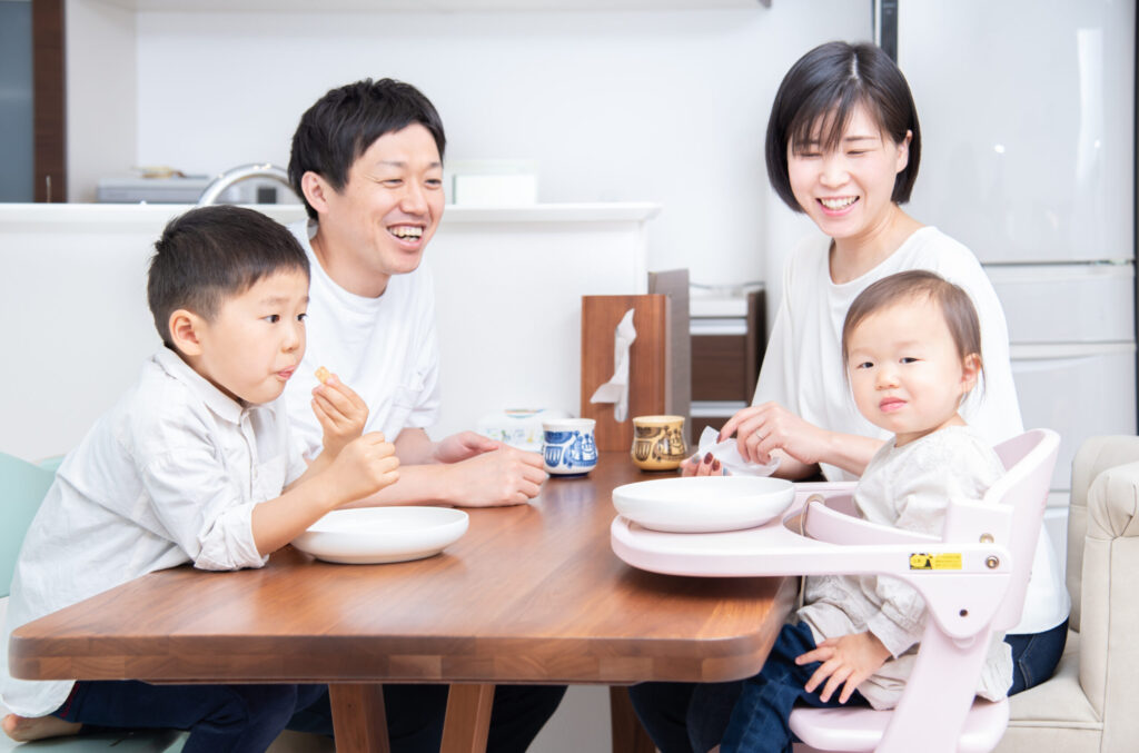 キッチンのすぐ横の食卓で小さな子どもと食事をするご家族（デモ）