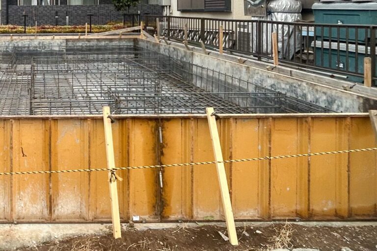 黄色い型枠が組まれた基礎と、その中に配された鉄筋