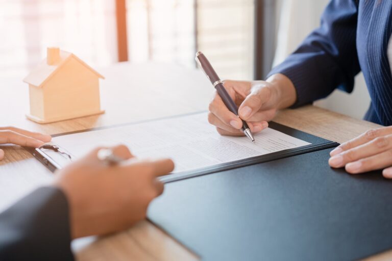 住宅の模型を前に、机の上で書類を見ながら初期のご相談を進める様子（デモ）